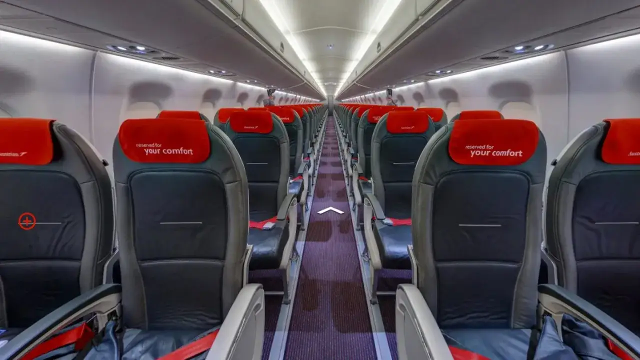 Puste wnętrze samolotu Embraer E195LR z czerwonymi zagłówkami 