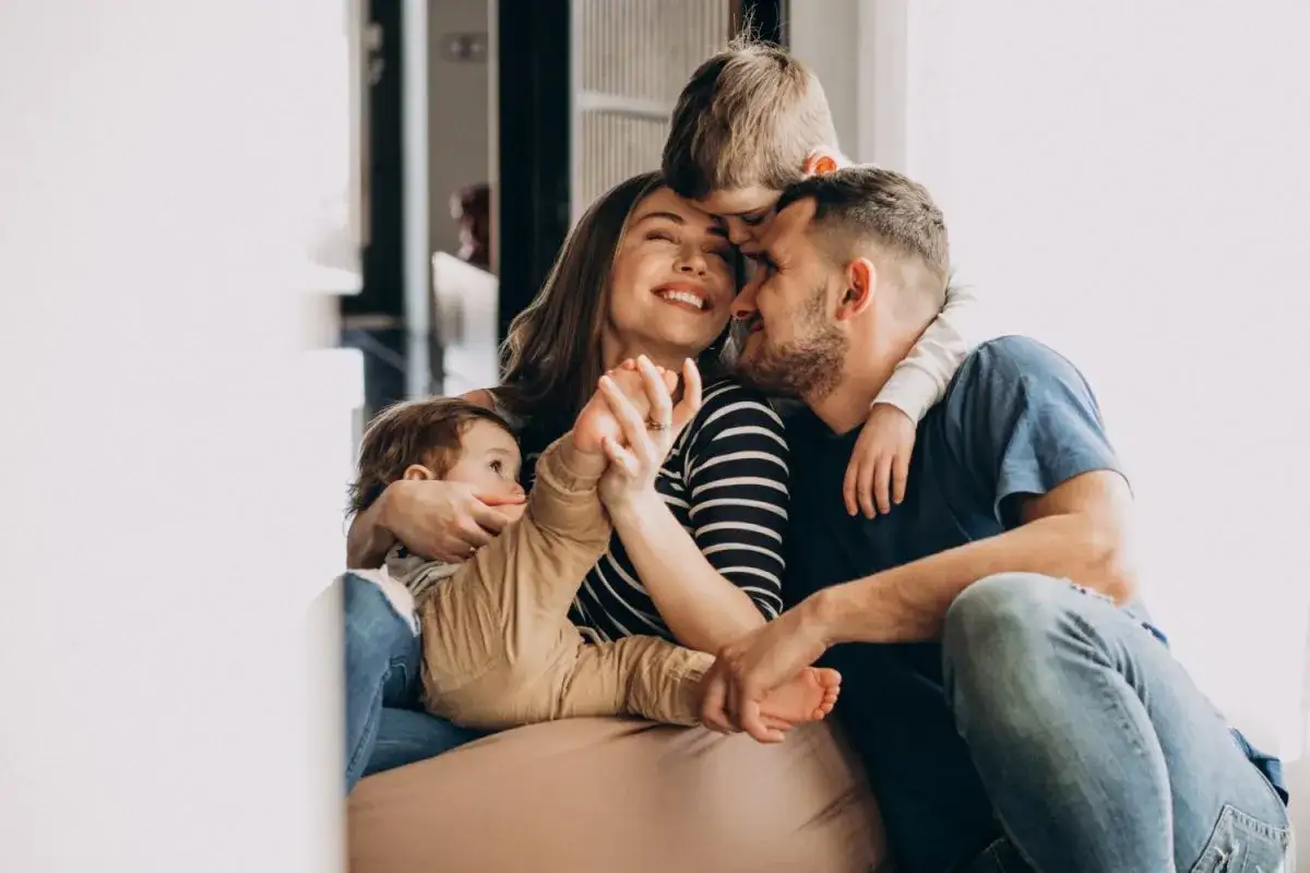 Familia disfrutando un momento de apego en niños de 6 a 12 años. Padres e hijos abrazados, transmitiendo amor y seguridad.