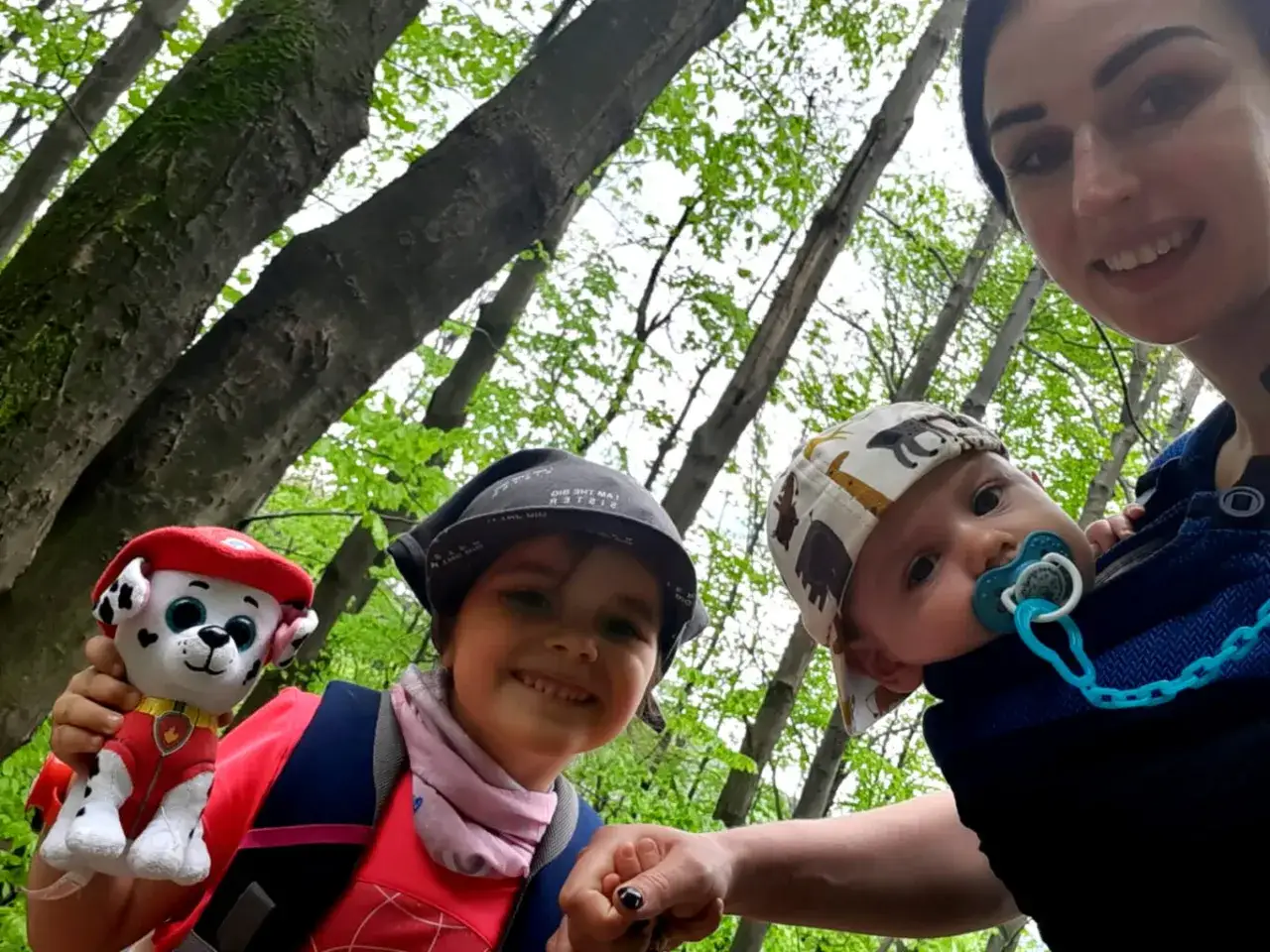 Mama z dziećmi w lesie. Warto zabrać w góry z dziećmi pluszaka i smoczek dla malucha.