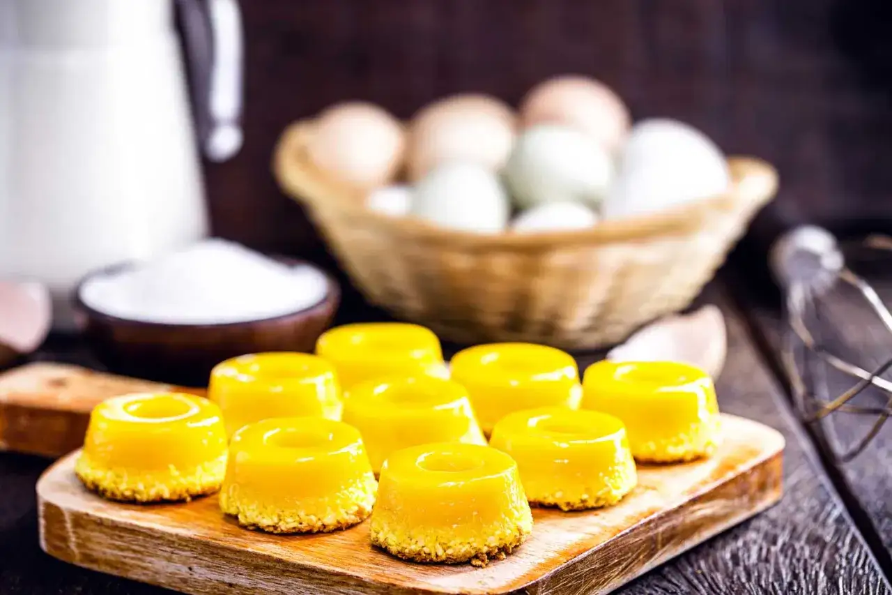 Douceurs jaunes vives, un dessert brésilien appétissant, entouré d'œufs, de lait et de sucre.