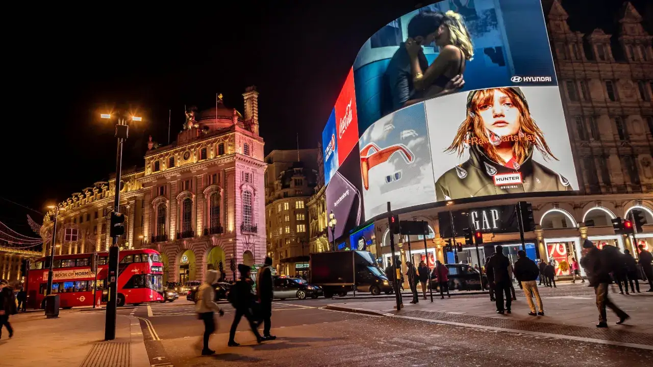 Nocny Londyn, Piccadilly Circus, tłumy ludzi, czerwony autobus, neony. Czy w Londynie jest bezpiecznie? Tętniące życiem centrum miasta.