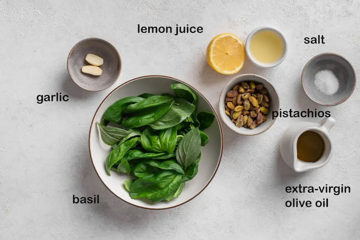 Zutaten für Pistazien-Pesto: Basilikum, Pistazien, Knoblauch, Zitronensaft, Olivenöl und Salz.