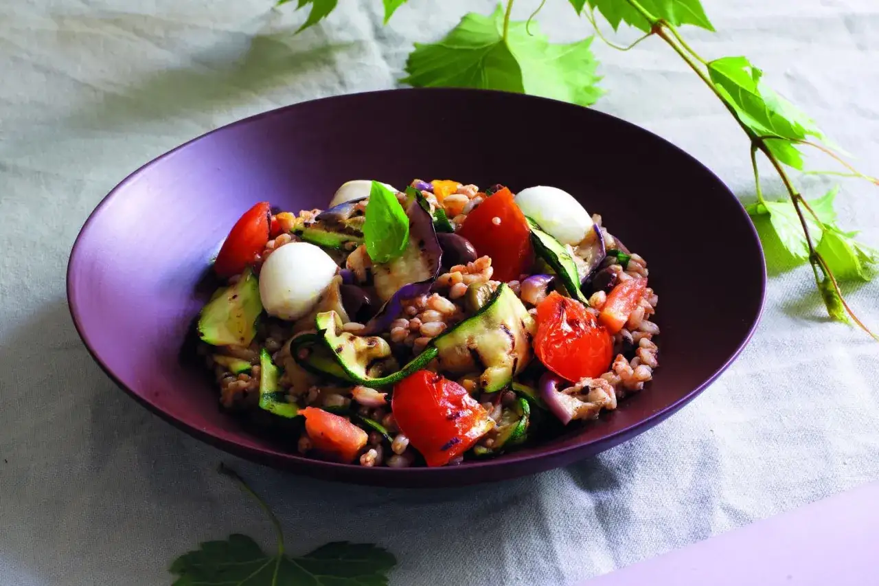 Insalata estiva di farro con verdure grigliate, pomodorini, mozzarelline e basilico. Perfetta tra le farro ricette fredde.