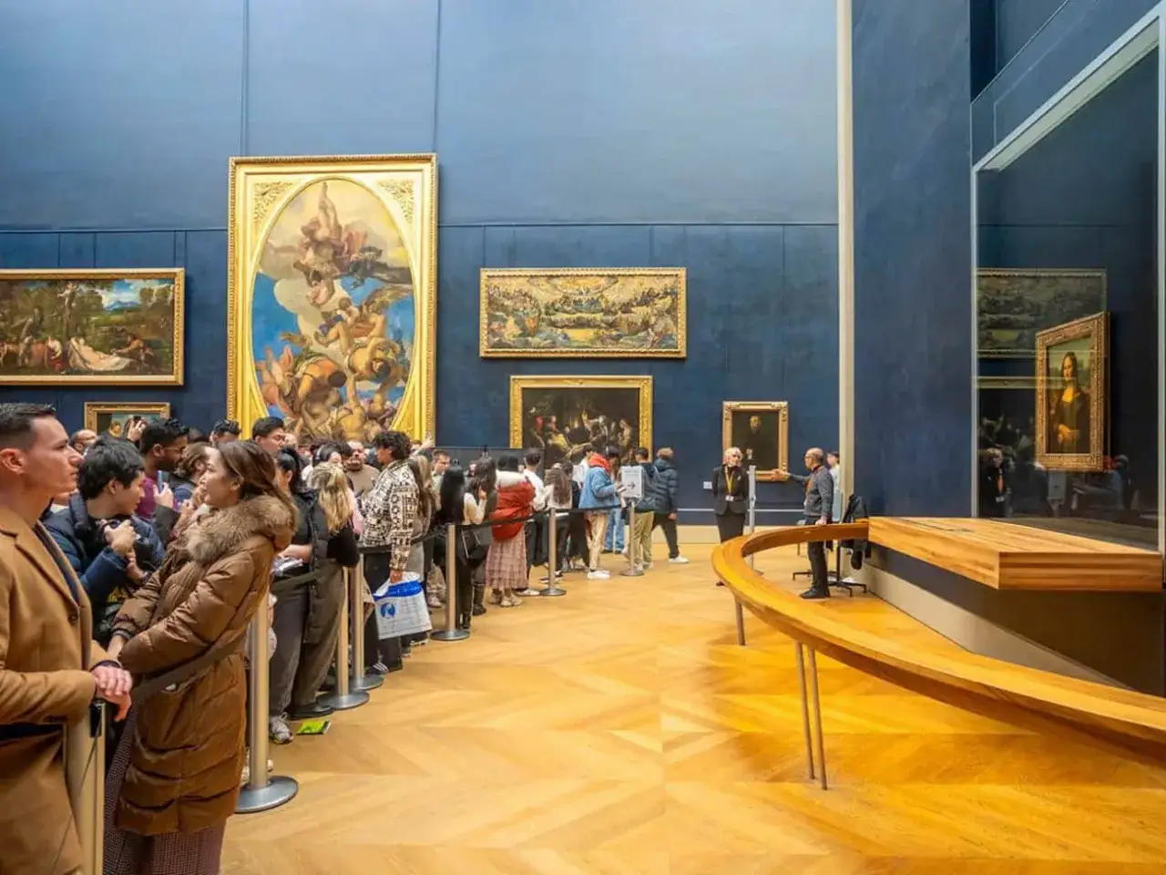 Menschen stehen Schlange, um die Mona Lisa in echt im Louvre zu sehen.