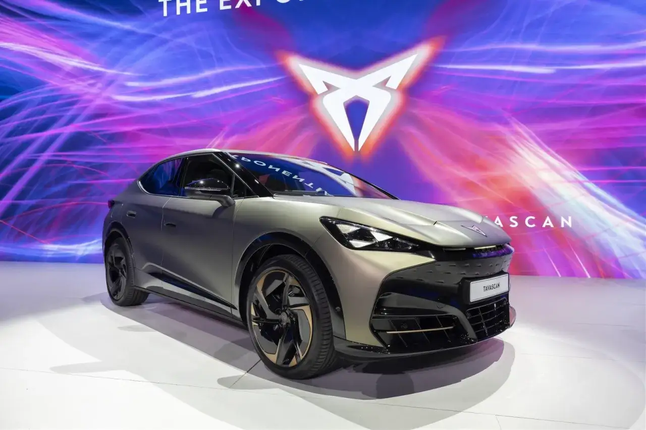 Nowy, elektryczny SUV Cupra Tavascan prezentuje się na tle dynamicznej grafiki.