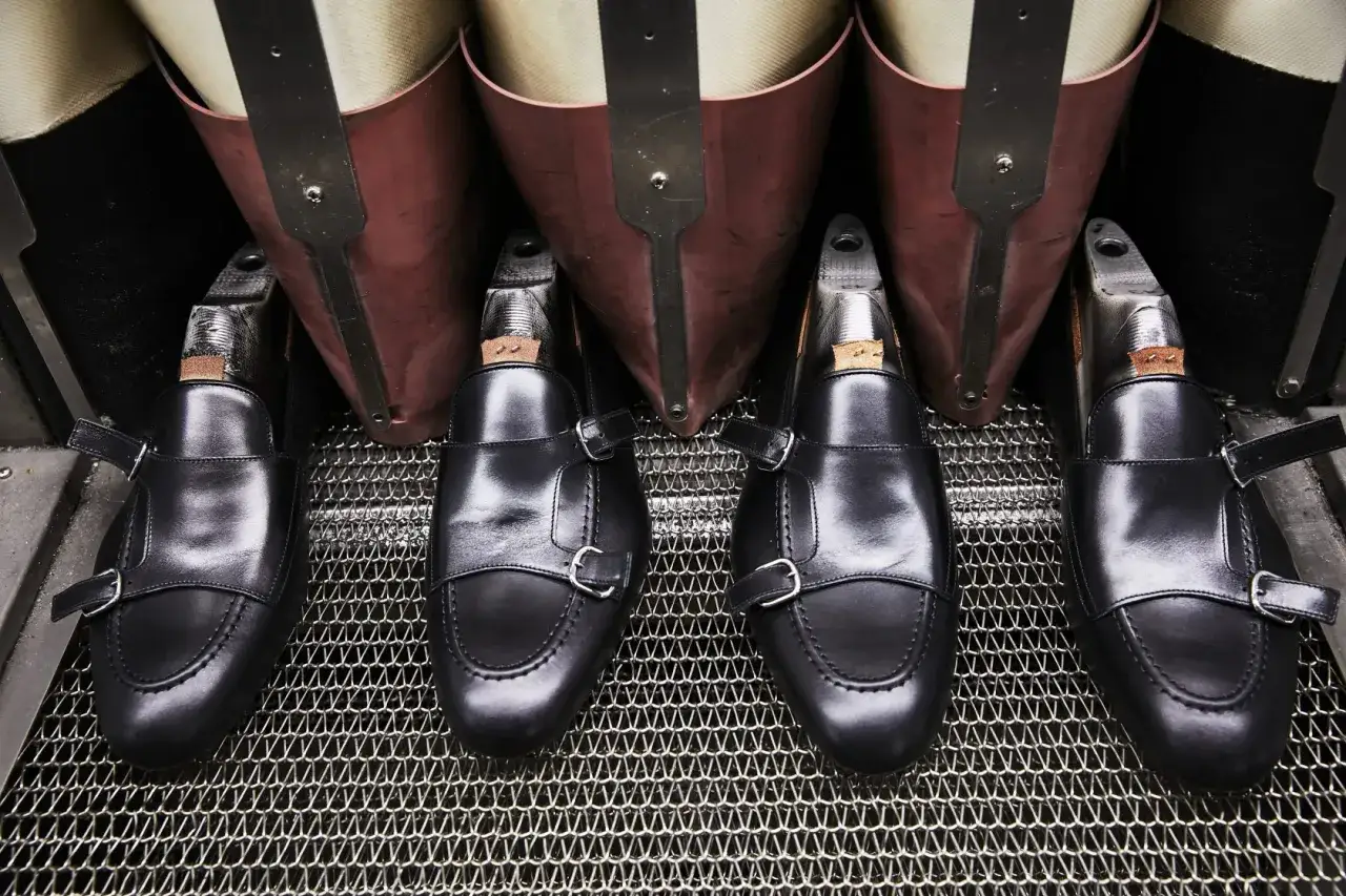Scarpe marchigiane famose, mocassini neri con doppia fibbia, pronti per la lucidatura.