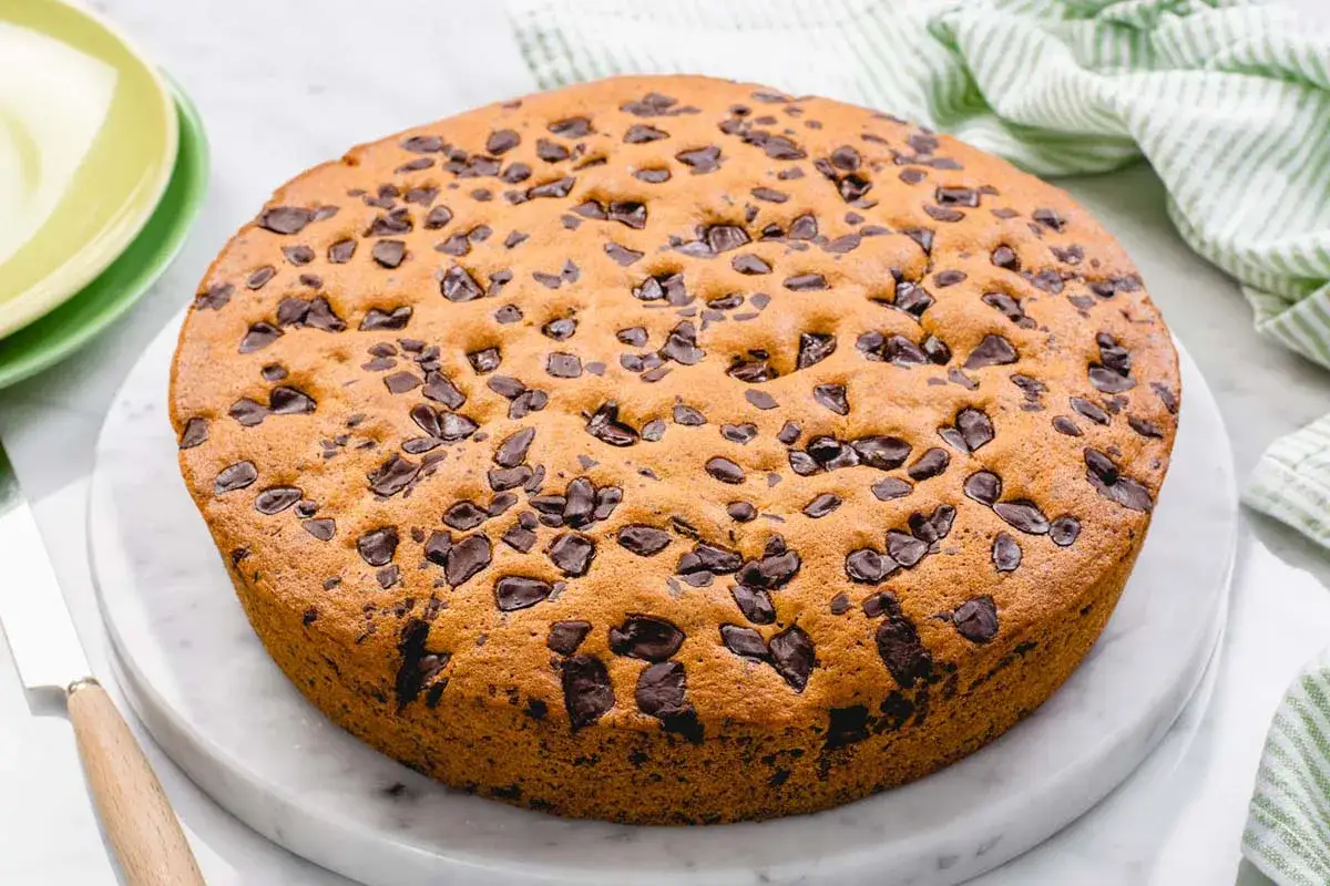 Torta soffice e dorata, ricca di gocce di cioccolato fondente, pronta per essere gustata.