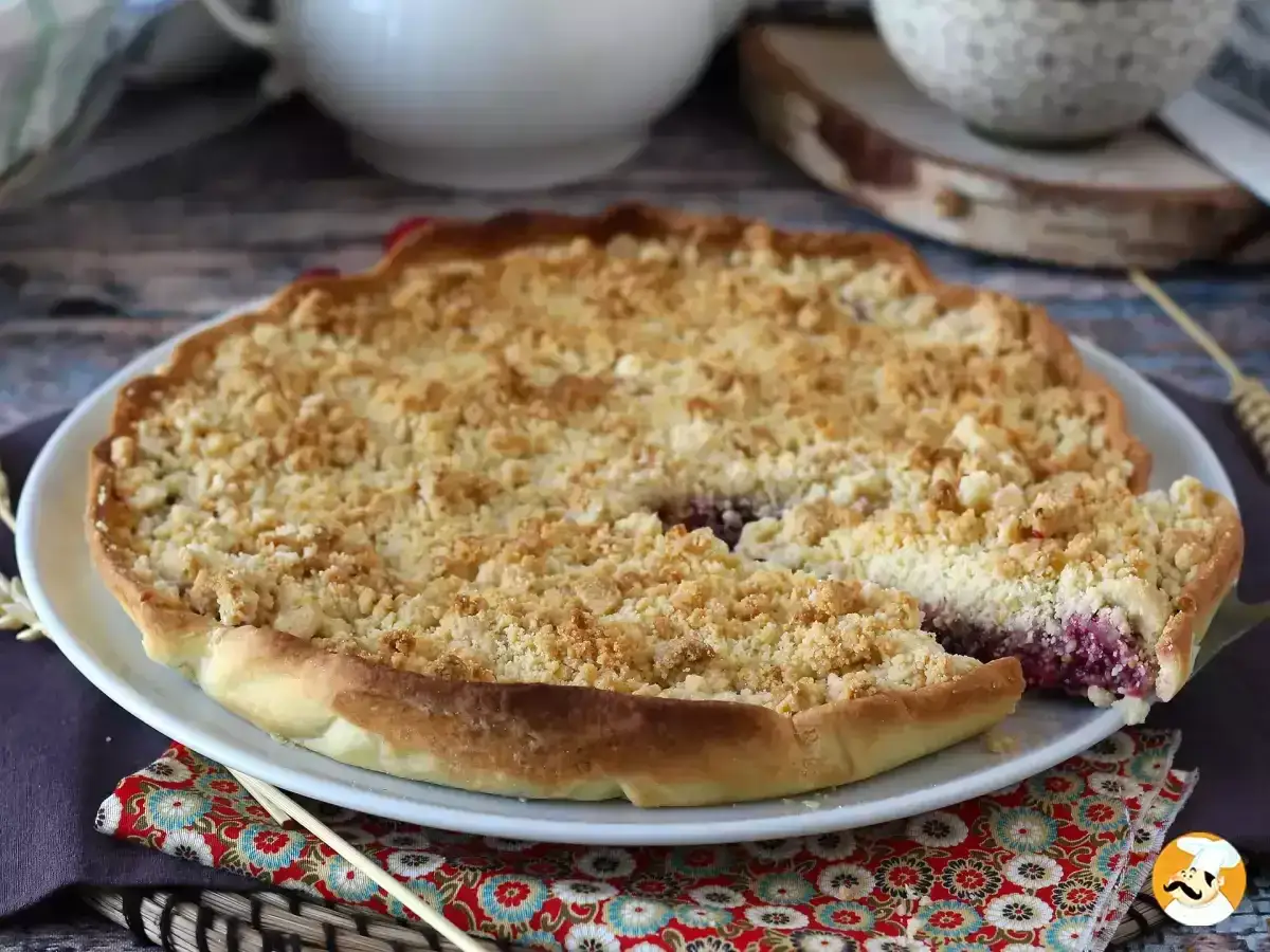 En saftig smulpaj med bär, perfekt för ett smuldeg recept. En bit är redan uppskuren.