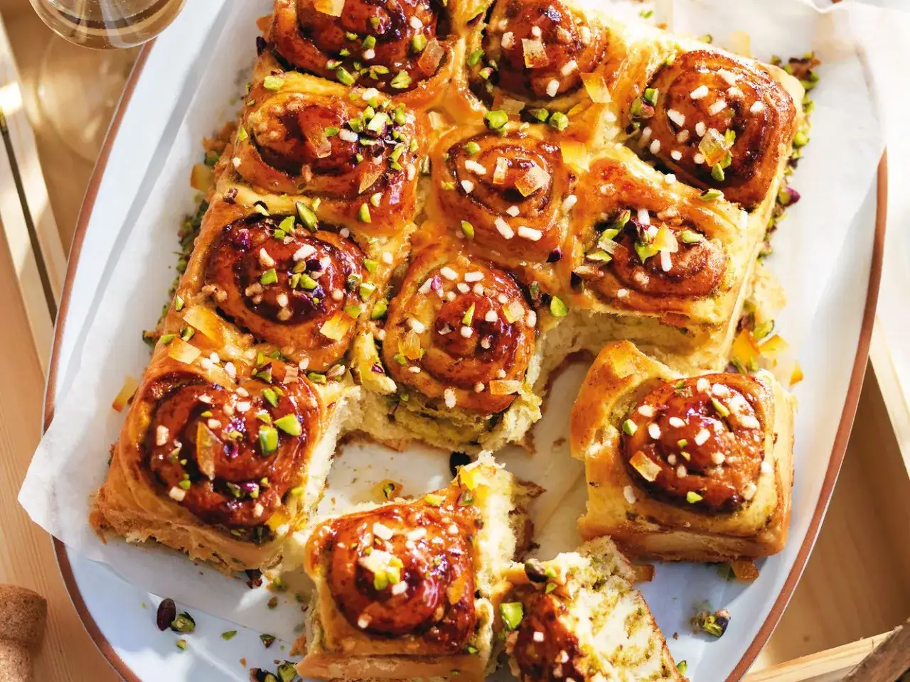 Deliziosa pitta nchiusa, dolci rotoli glassati con pistacchi e scorza d'arancia candita, pronti per essere gustati.