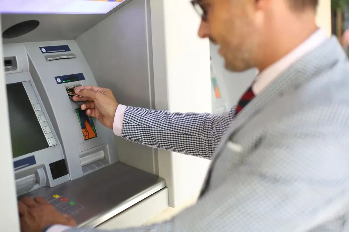 Mężczyzna wkłada kartę do bankomatu, ale bankomat nie wypłacił pieniędzy, a pobrał z konta.