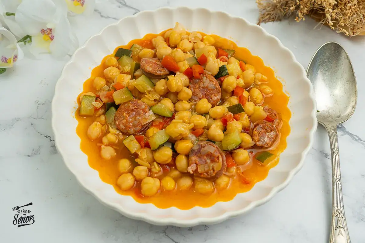 Un plato de garbanzos de bote con chorizo, calabacín y pimiento rojo. Una de las muchas recetas con garbanzos de bote, fácil y deliciosa.