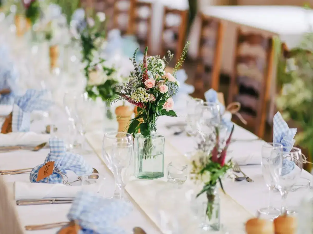 Arreglos florales delicados y servilletas a cuadros azules definen estos estilos de boda r&uacute;sticos y encantadores.