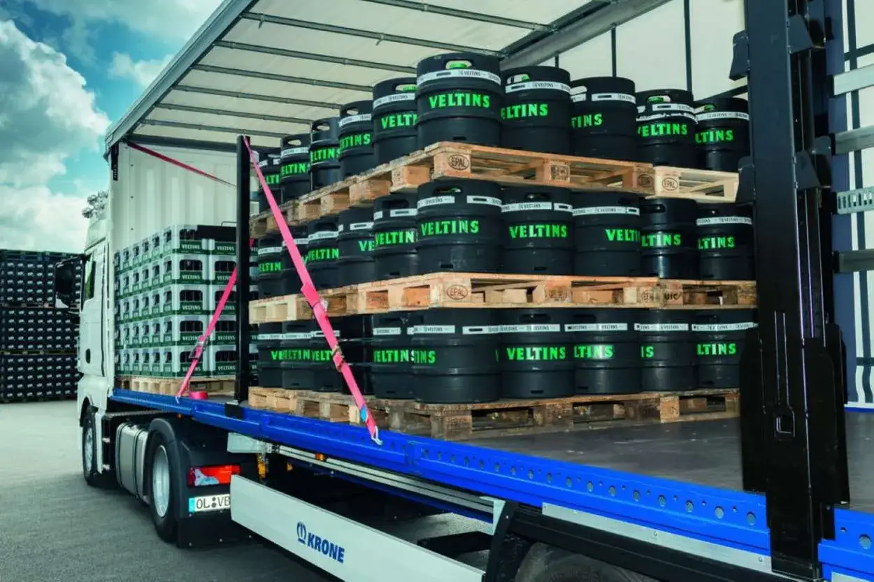 Lkw richtig beladen mit Bierf&auml;ssern und Kisten. Ladungssicherung mit pinken Gurten.