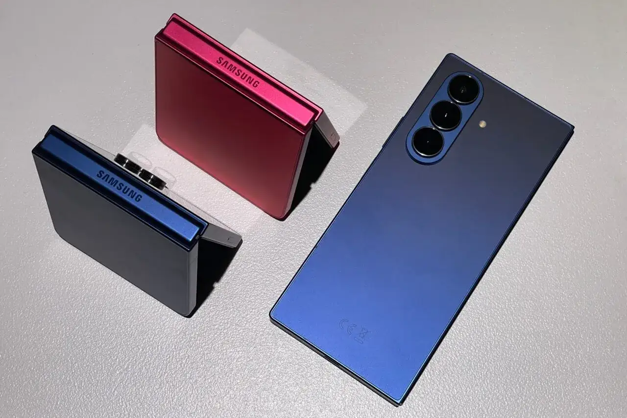 Dwa składane telefony Samsung w kolorach niebieskim i różowym oraz nowy, niebieski smartfon Samsung.
