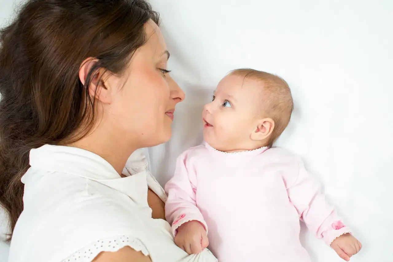 Mama patrzy na swoje dziecko, które widzi świat jak 3 miesięczne dziecko – rozmazane kształty i jasne kolory.