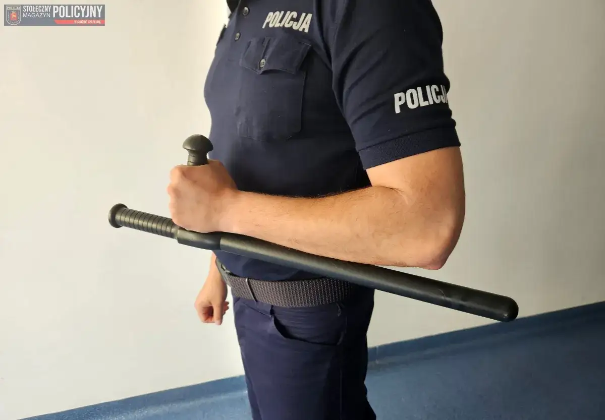 Policjant trzyma pałkę tonfa. To narzędzie do samoobrony, kt&oacute;re może być używane w sytuacjach kryzysowych.