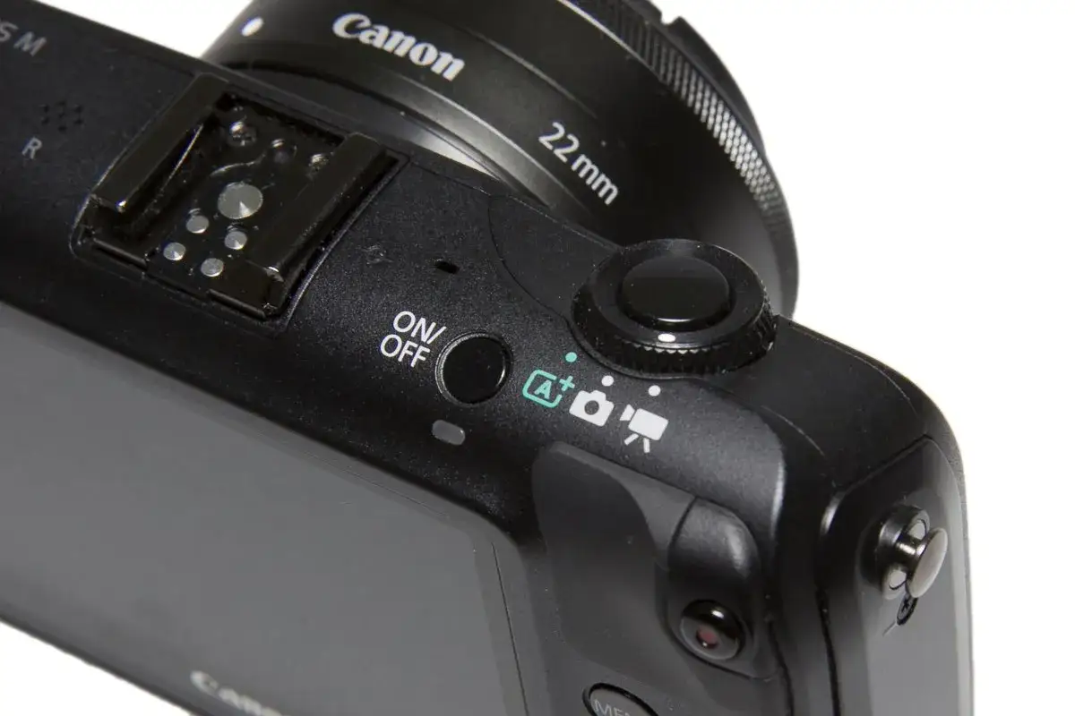 Czarne przyciski aparatu Canon EOS, w tym ON/OFF i pokrętło trybów, idealne do nauki fotografii.