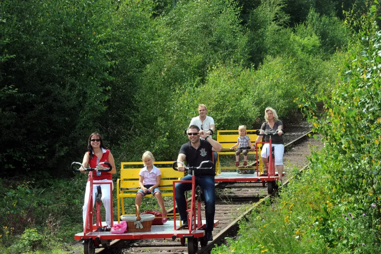 Familien genie&szlig;en eine Draisinenfahrt NRW durch gr&uuml;ne Natur.