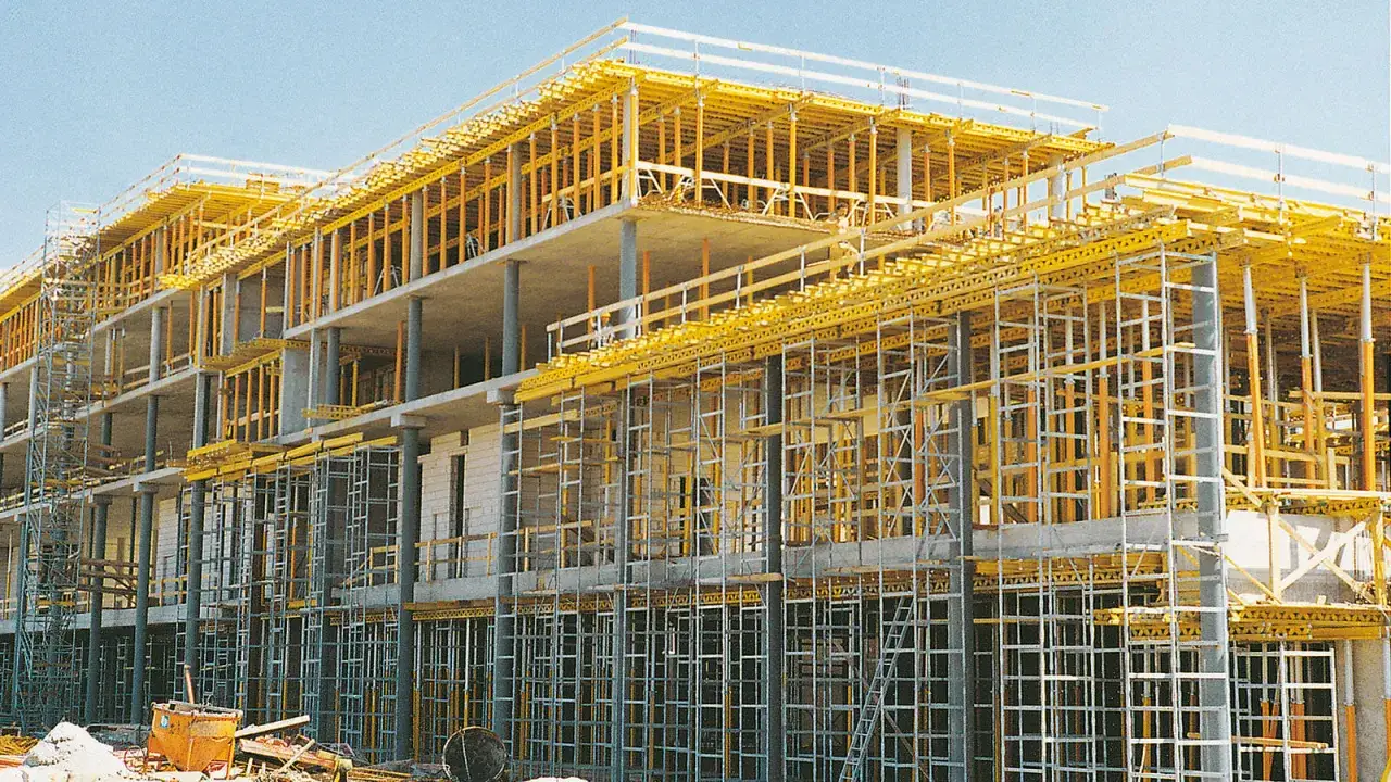 Estructura de hormigón armado con un sistema de encofrado amarillo y soportes metálicos, parte de un **provisional de obra** en construcción.
