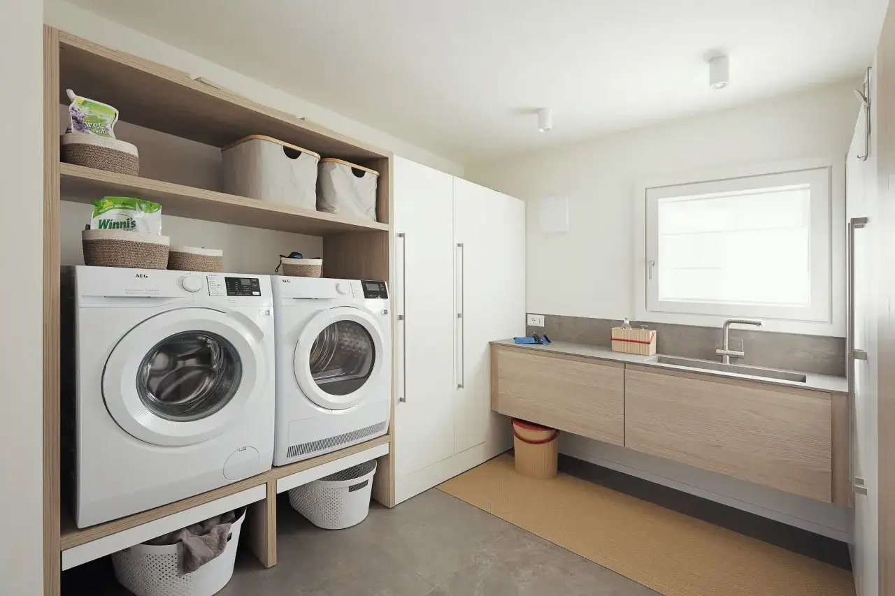 Progetto bagno con lavanderia: lavatrice, asciugatrice, lavabo e armadi. Organizzazione funzionale per la casa.
