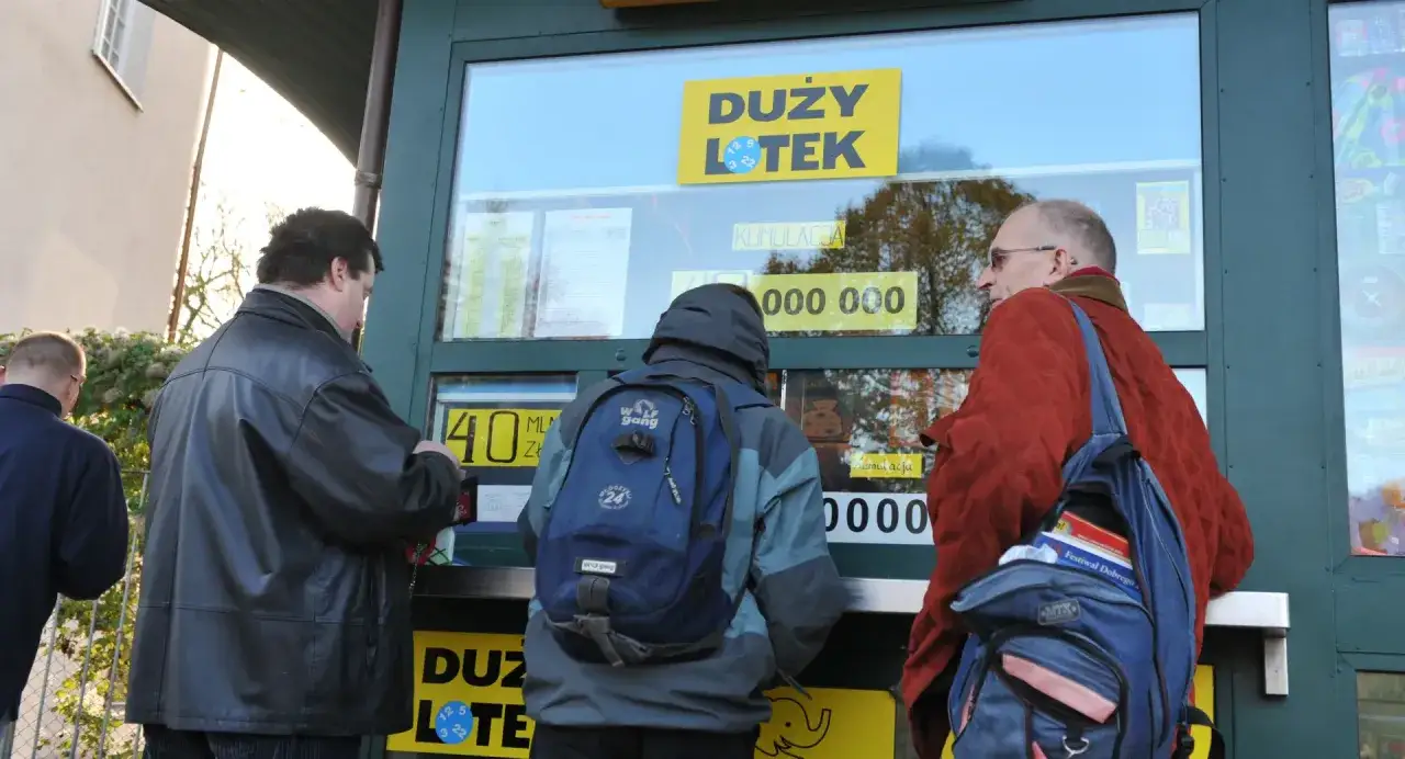 Trzech mężczyzn kupuje losy w punkcie sprzedaży 