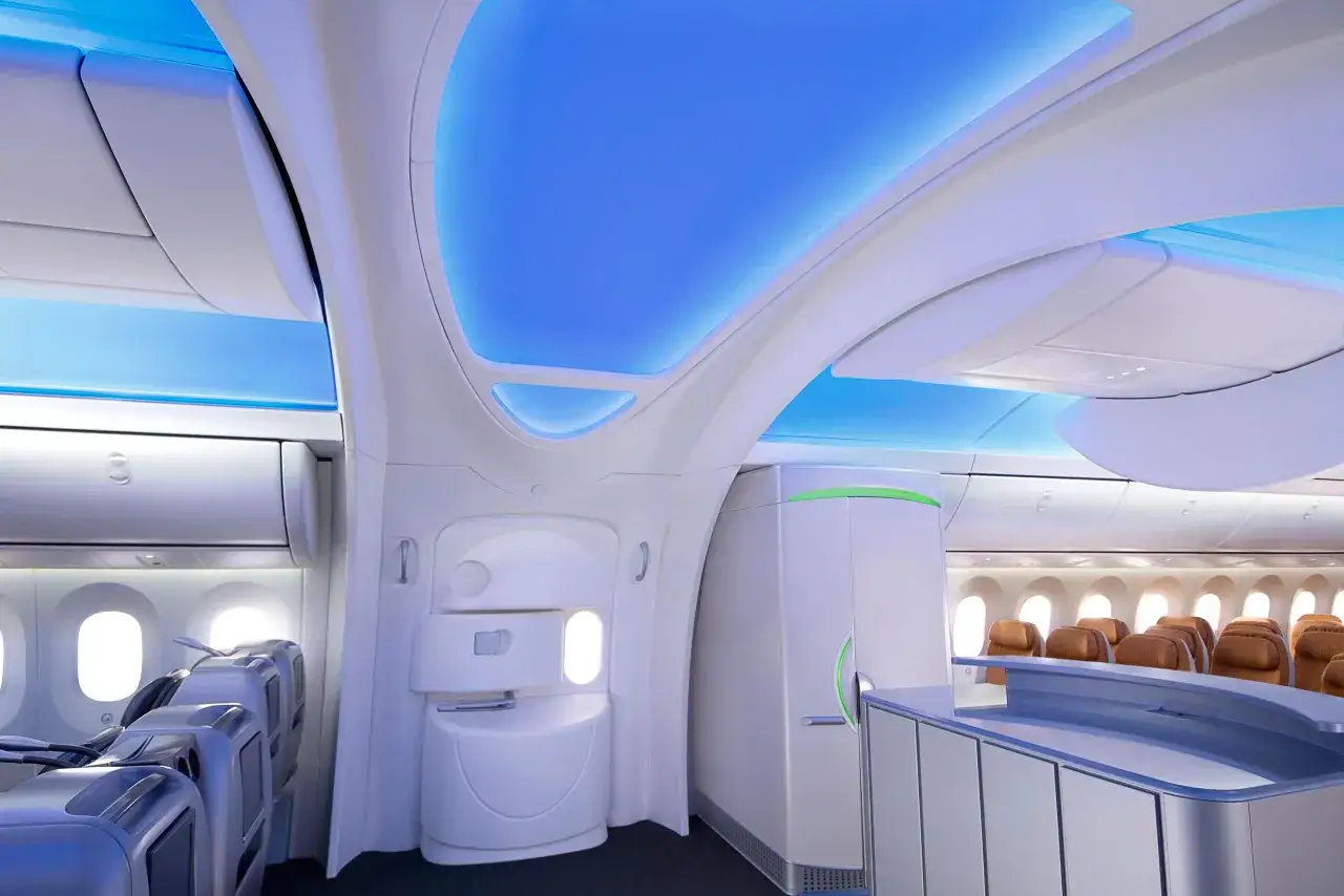Nowoczesne wnętrze Dreamlinera 787 z niebieskim podświetleniem sufitu, siedzeniami i ladą.