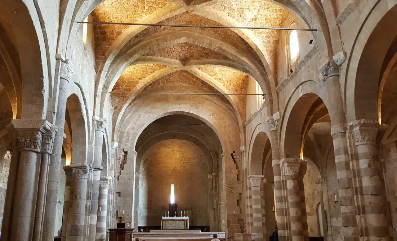 Interno di un'antica abbazia con volte a crociera e archi in pietra. Un luogo dove c'è così tanta cosa vedere, tra storia e architettura.