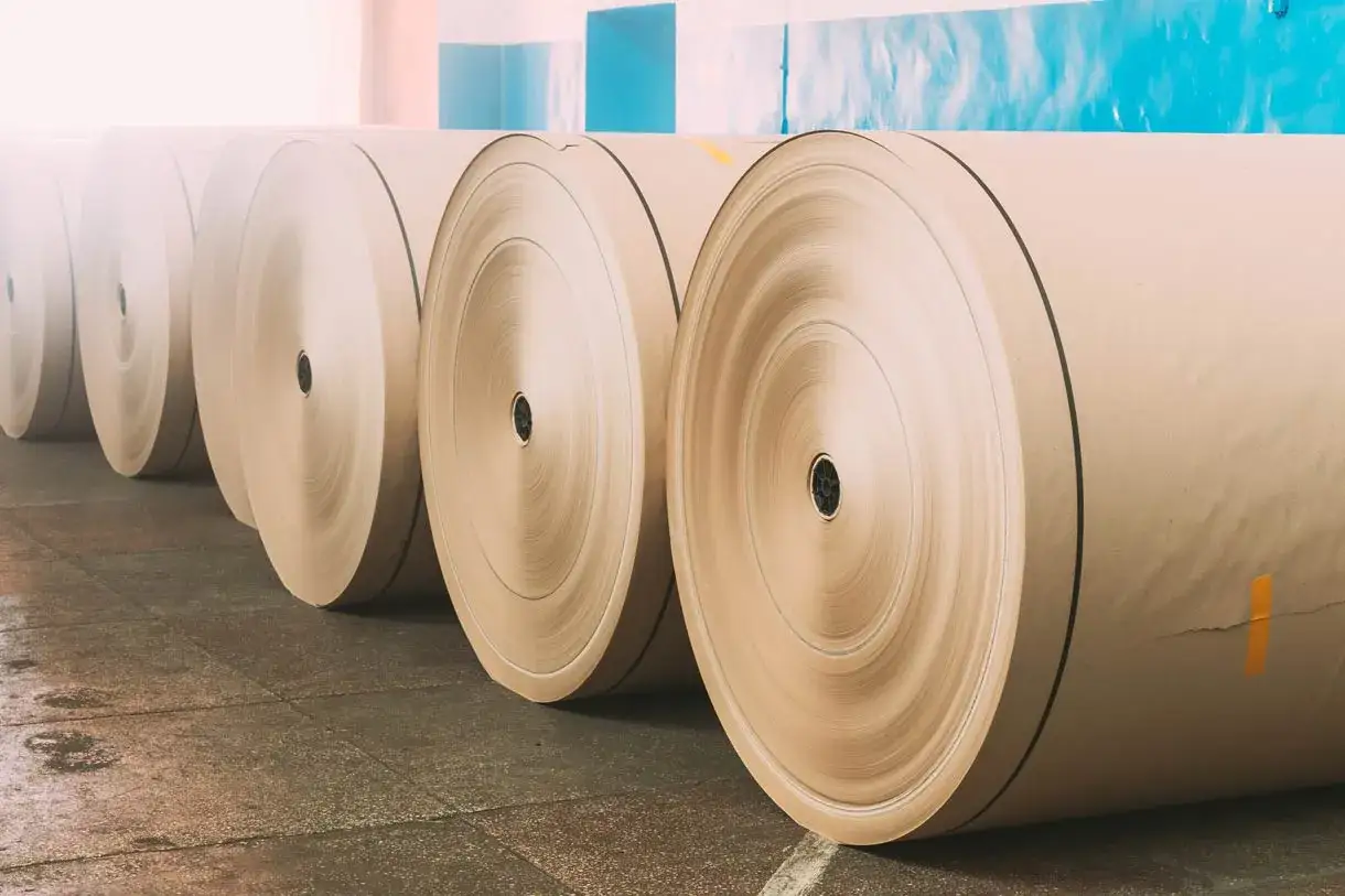 Rollos de papel offset apilados en un almac&eacute;n, listos para la impresi&oacute;n.