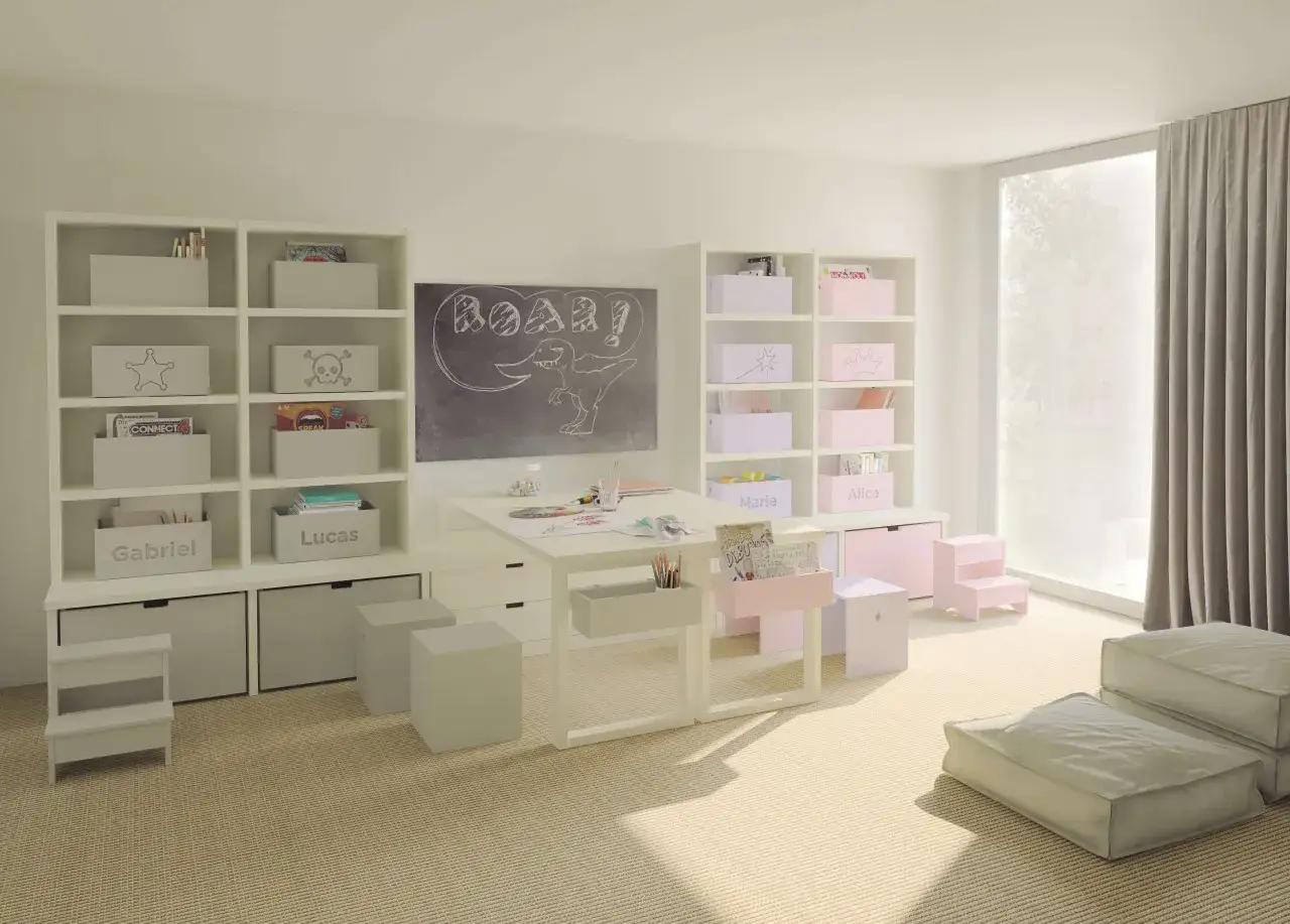 Stanza giochi bambini luminosa con lavagna, scrivania, librerie piene di giochi e contenitori personalizzati.