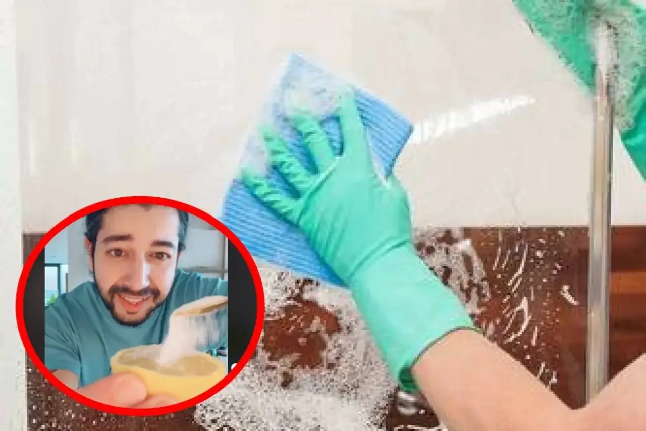 Mężczyzna pokazuje, jak zrobić domowy środek do czyszczenia kabiny prysznicowej ocet i soda. Ręka w rękawiczce czyści szklaną ściankę.