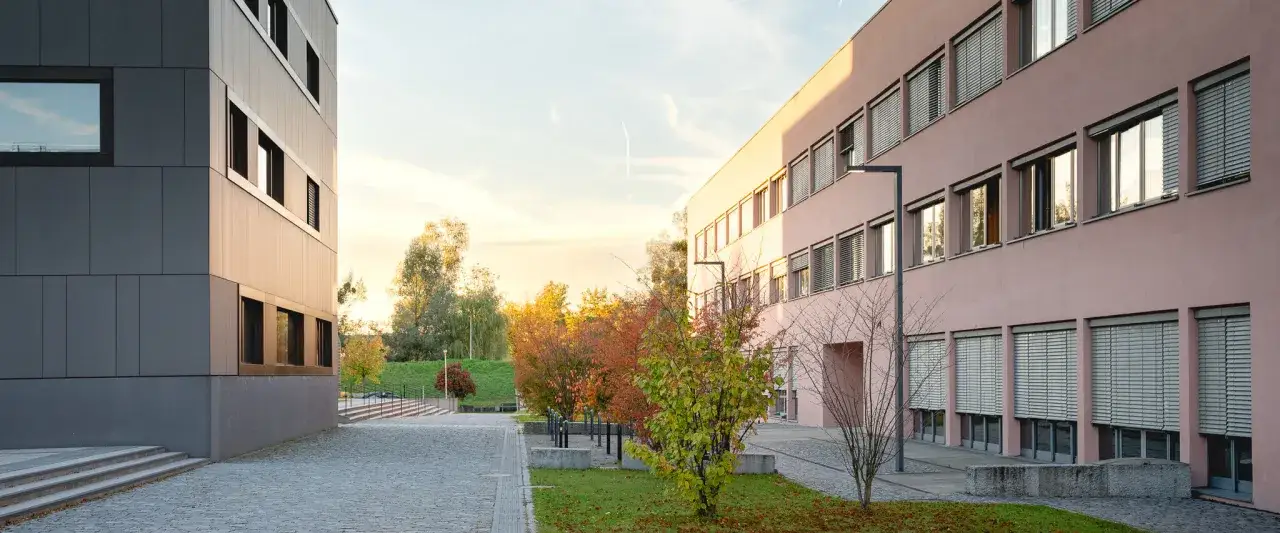 Moderne Gebäude mit vielen Fenstern und Herbstlaub. Ein Ort, der zum Lernen einlädt, wie es an vielen Hochschulstandorten der Fall ist.