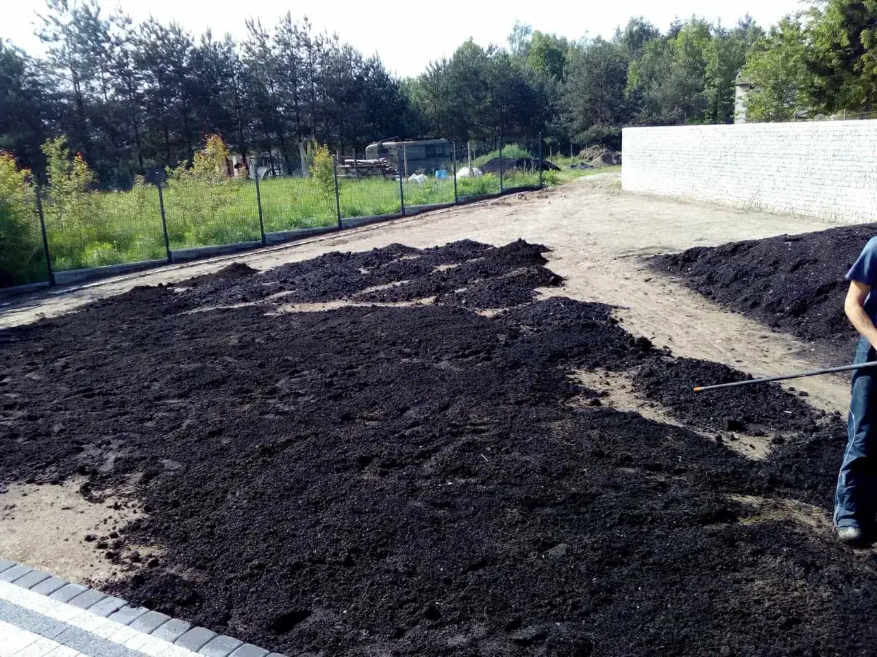 Przygotowany teren pod zasiew trawy. Ciemna ziemia czeka na nasiona, idealny czas kiedy siac trawe.