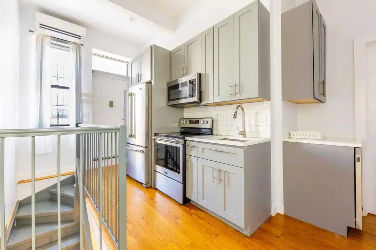 Kleine, helle K&uuml;che mit Edelstahlger&auml;ten, grauen Schr&auml;nken und Holzboden &ndash; perfekt f&uuml;r dein Auslandssemester New York.