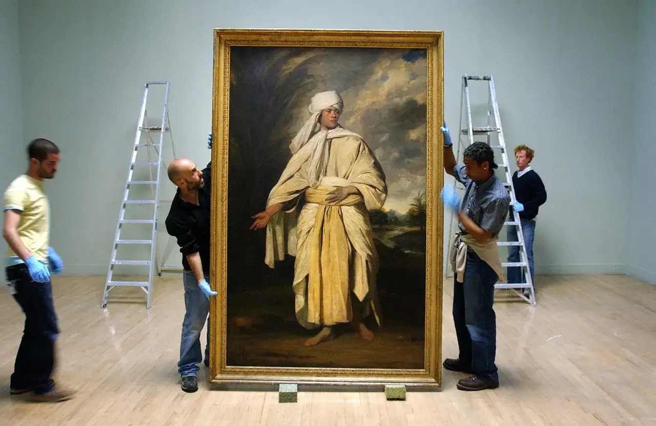 Museum workers carefully handle a large portrait of Omai, a Polynesian visitor to London in the 18th century.