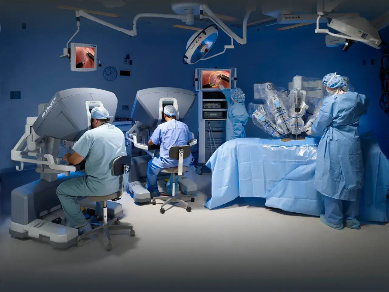 Chirurdzy sterują robotem da Vinci, wykonując precyzyjną operację.
