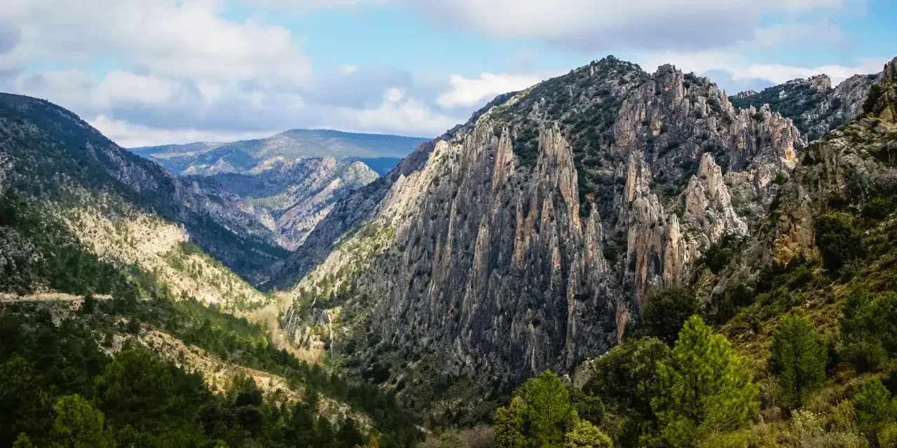 Majestuosas formaciones rocosas y verdes pinares en la ruta del silencio. Un paisaje montañoso que invita a la contemplación.