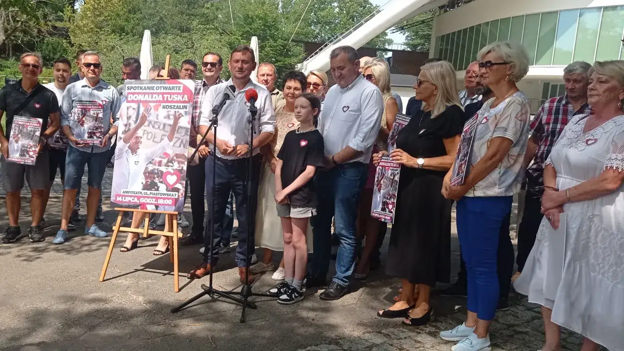 Spotkanie otwarte Donalda Tuska w Koszalinie. Ludzie stoją przed plakatem z jego wizerunkiem.