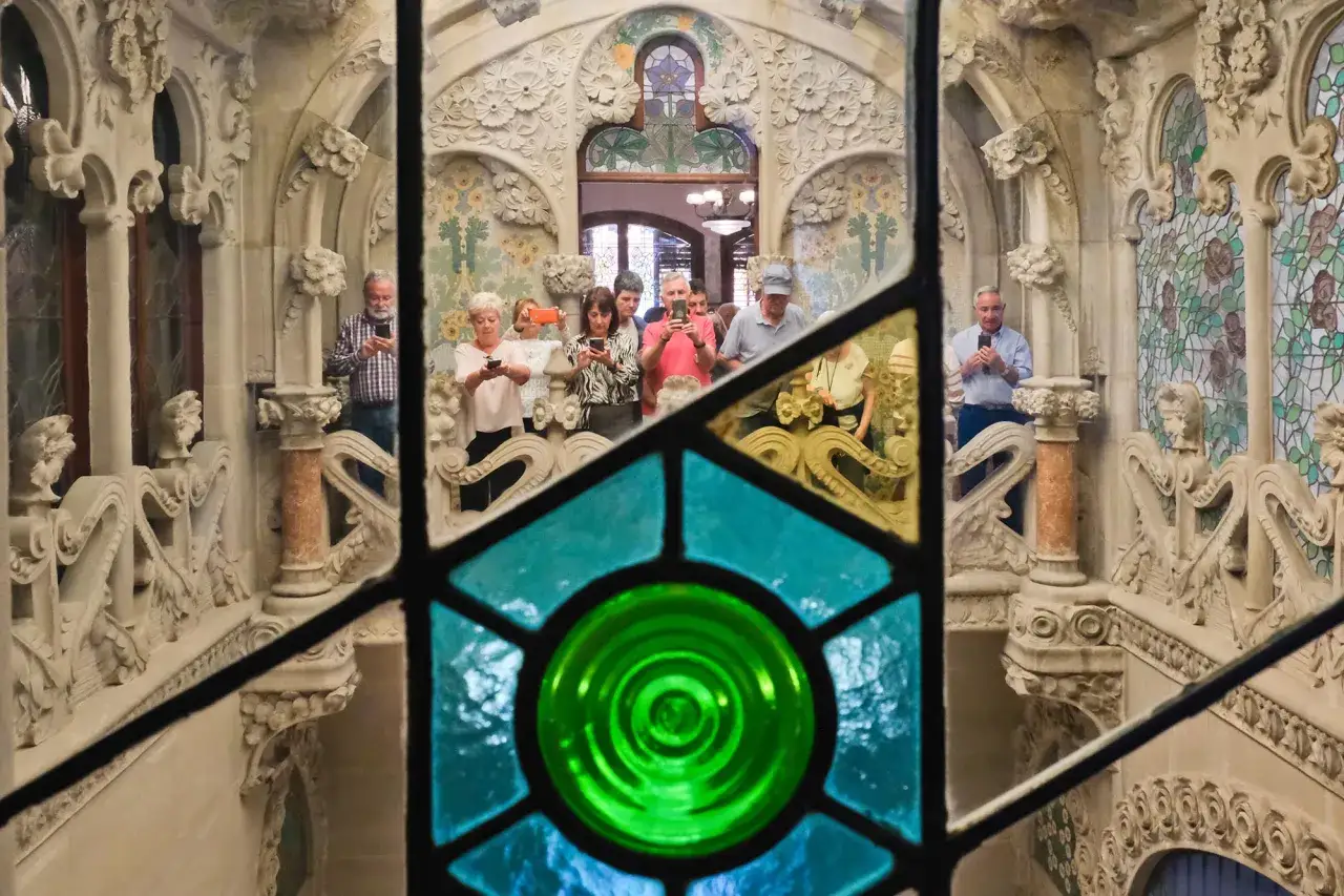 Turistas fotograf&iacute;an la ornamentada escalera de la Casa Nav&agrave;s en Reus, admirando su arquitectura modernista.