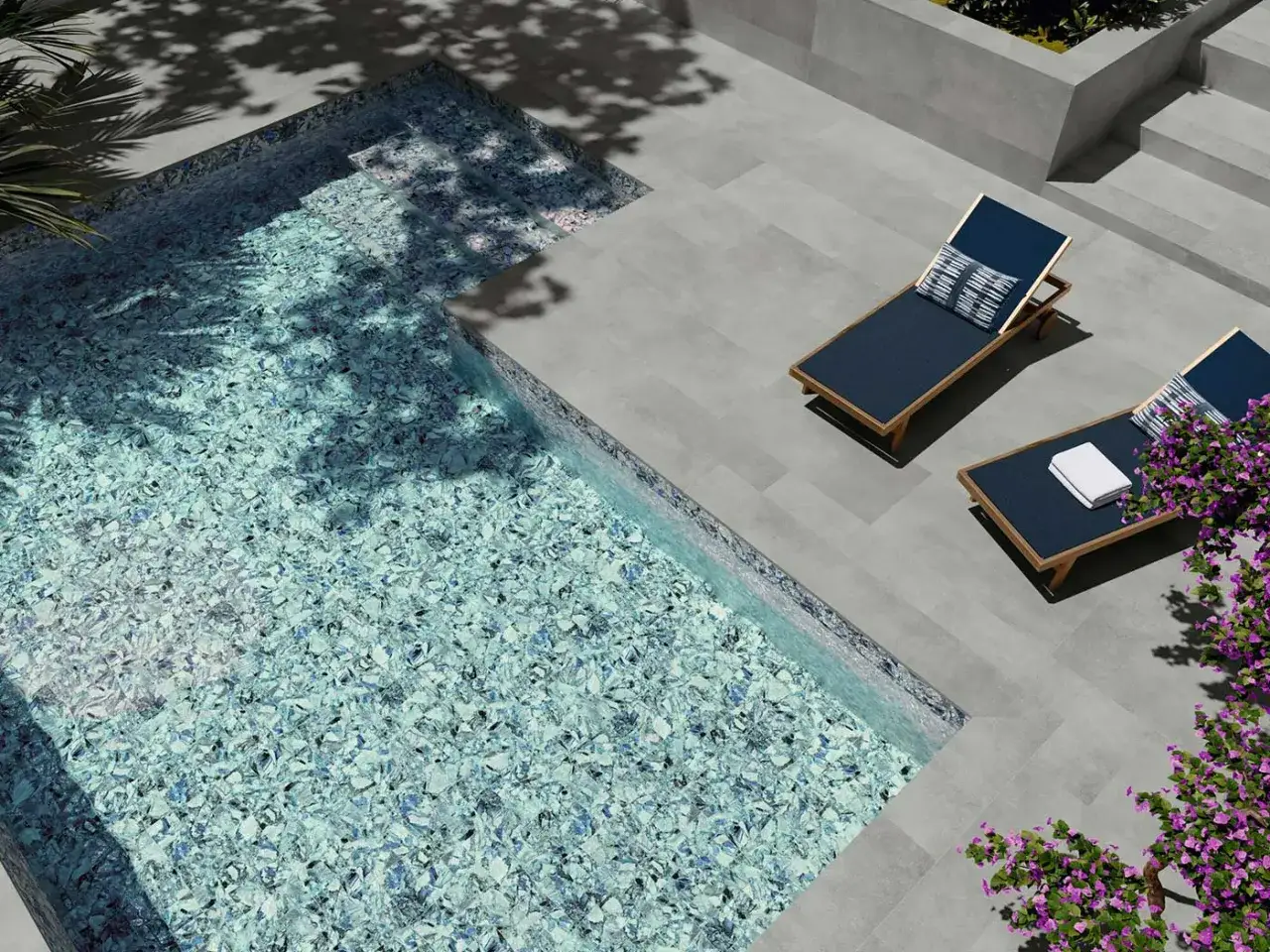 Elegantes colores de piscinas modernas con mosaicos azules y blancos. Dos tumbonas invitan al descanso junto a la piscina.