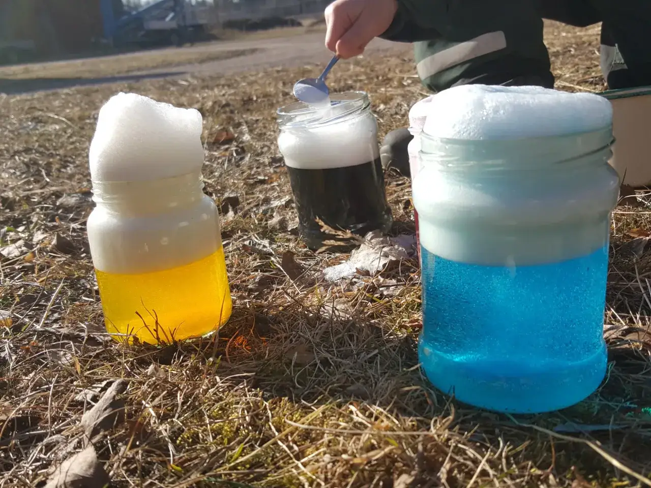Färgglada burkar med skum som bubblar över, en del av en rolig burken lek utomhus.