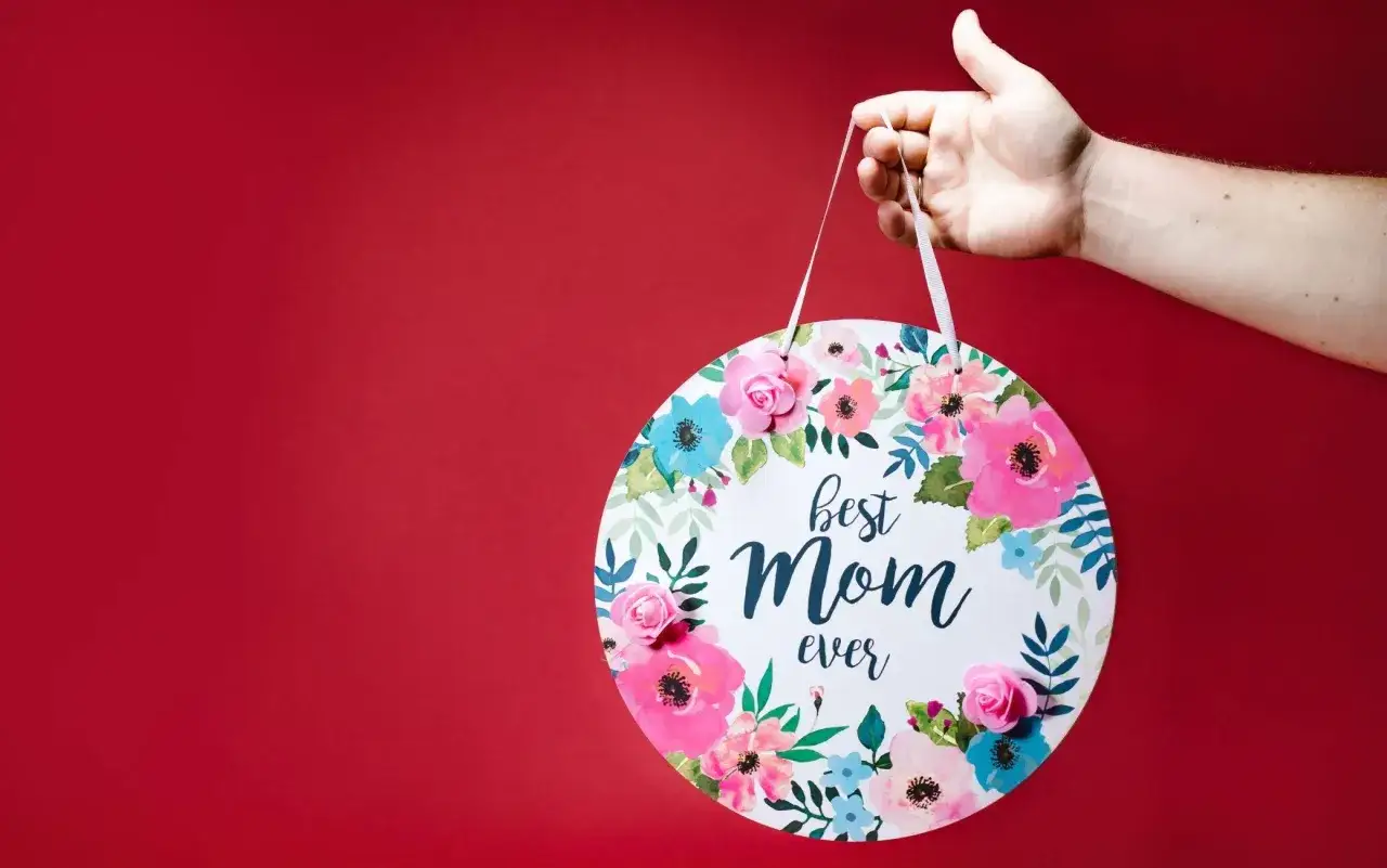 Un lavoretto creativo per la festa della mamma: un tondo decorato con fiori e la scritta 