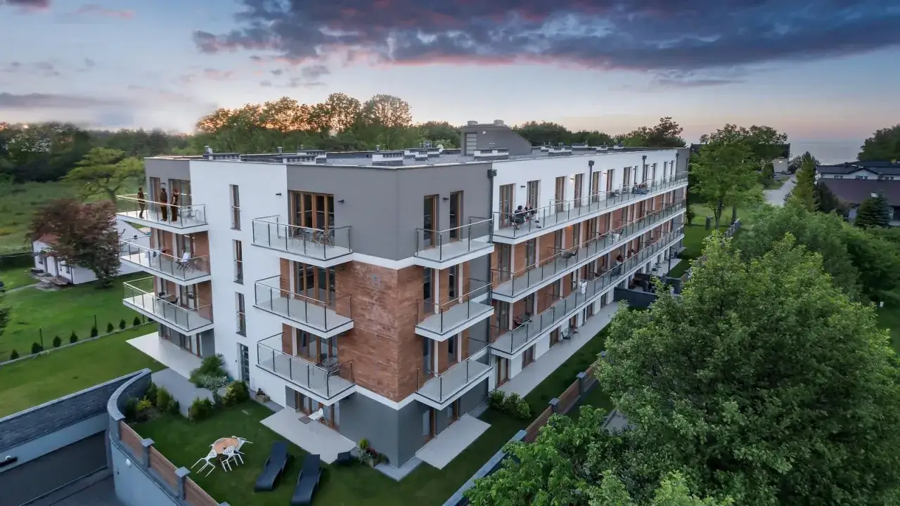 Nowoczesne apartamenty Jastrzębia Góra z widokiem na morze. Balkony z przeszklonymi balustradami i drewnianymi elementami.