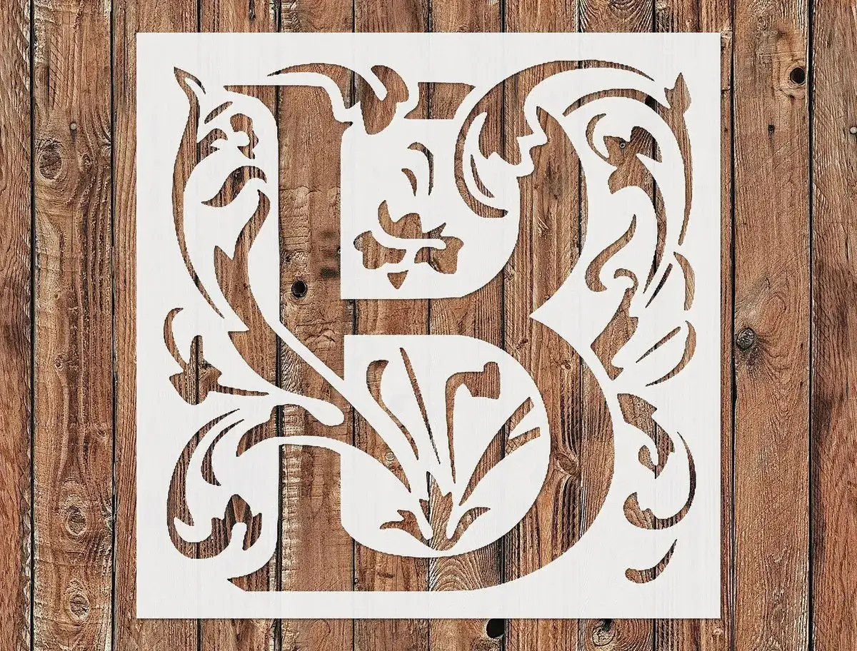 Pochoir blanc avec une lettre B ornée de motifs floraux, prêt pour une écriture sur bois.