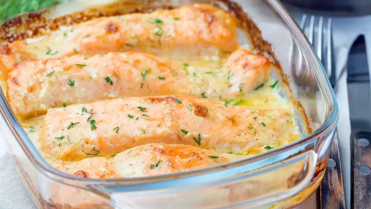 Vier saftige Lachsfilets in cremiger Sahnesauce, &uuml;berbacken und mit frischen Kr&auml;utern bestreut. Ein k&ouml;stliches Lachs Sahne Gratin.