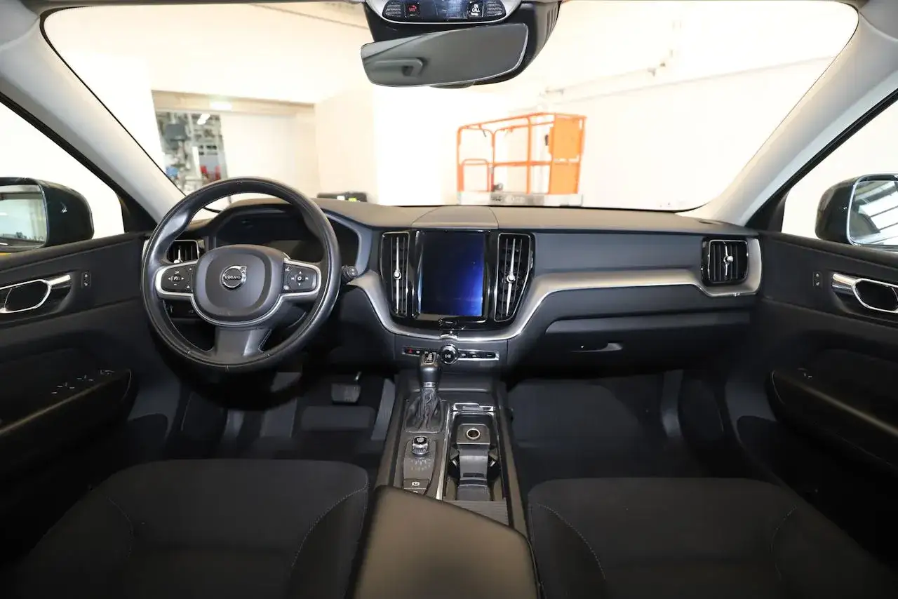 Interi&ouml;r i en Volvo Momentum med fokus p&aring; ratten, mittkonsolen och den stora sk&auml;rmen.