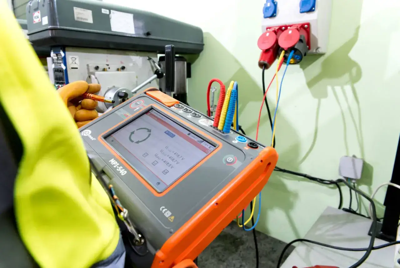 Elektryk dokonuje pomiarów przy użyciu miernika MPI-540, przygotowując protokół odbioru instalacji elektrycznej.