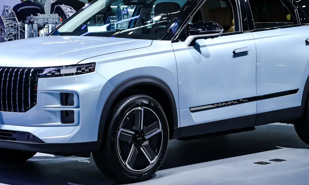 Un moderno SUV azul claro, un veh&iacute;culo el&eacute;ctrico enchufable, muestra su parrilla vertical y llantas de dise&ntilde;o.