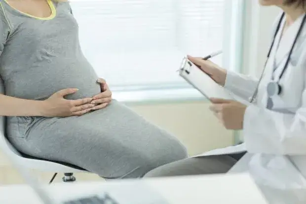 Kobieta w ciąży czytająca ulotkę o programie