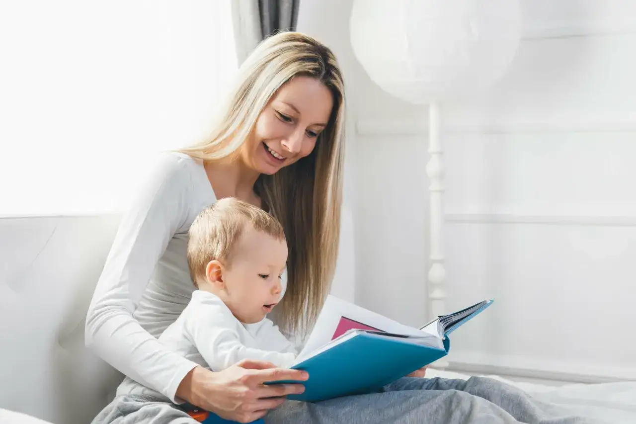 Mama z uśmiechem czyta dziecku książkę, wspierając naukę czytania.