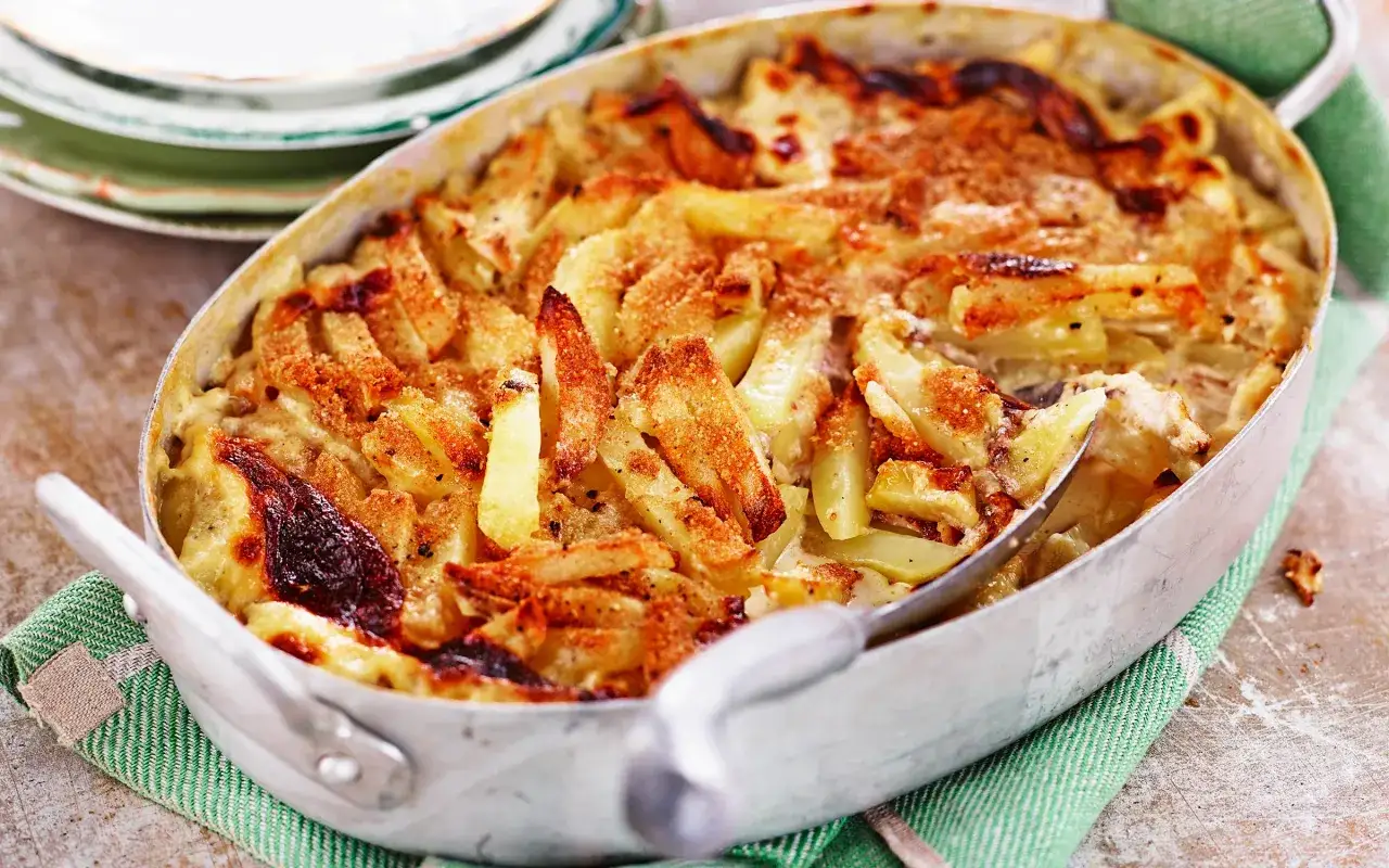 En gyllene Janssons frestelse med potatis och gräddig sås, redo att serveras.